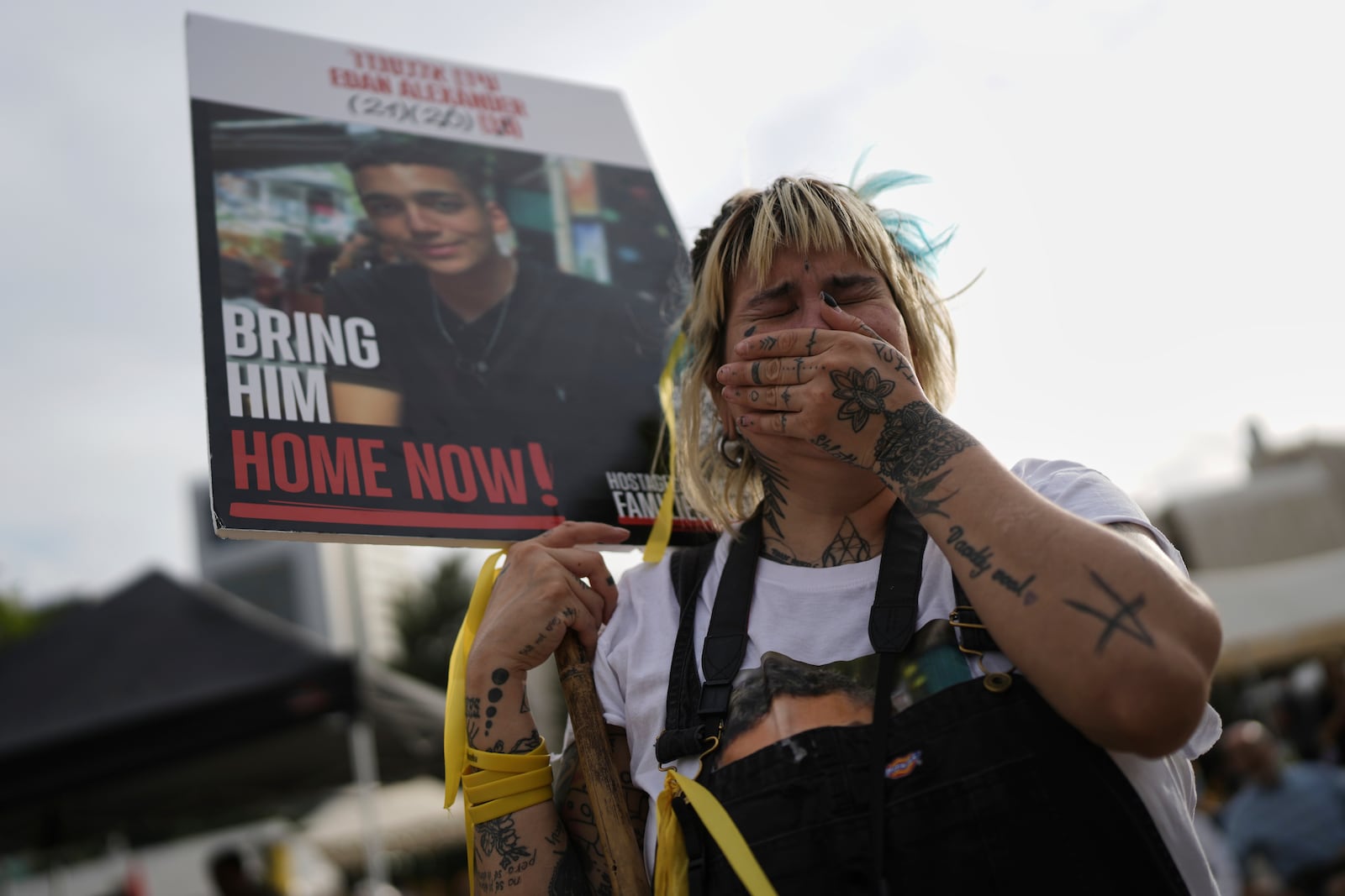 A woman cries as she gathers with others to watch a live broadcast of Israeli-American soldier Edan Alexander to be released from Hamas captivity in Gaza, at a plaza known as the hostages square in Tel Aviv, Monday, May 12, 2025. Alexander was abducted during the Hamas-led attack on his base on October 7, 2023. (AP Photo/Oded Balilty)