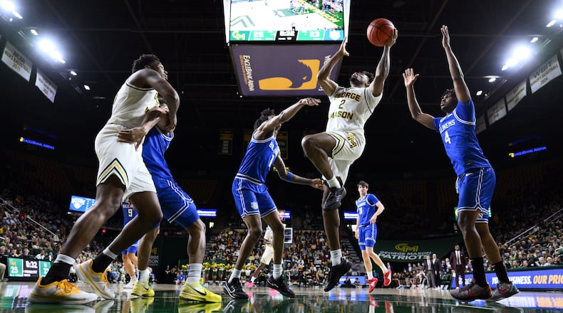 George Mason guard Jahari Long (2) goes to the basket past Saint Louis guard Amari McCottry (4) during the first half of an NCAA college basketball game, Saturday, March 7, 2026, in Fairfax, Va. (AP Photo/Nick Wass)