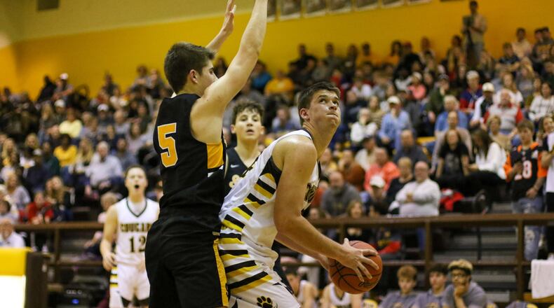Kenton Ridge senior Collin Perkins makes a move to the basket while being guarded by Shawnee’s Isaac Siemon during their game on Friday night in Springfield. The Cougars won 48-45. CONTRIBUTED PHOTO BY MICHAEL COOPER