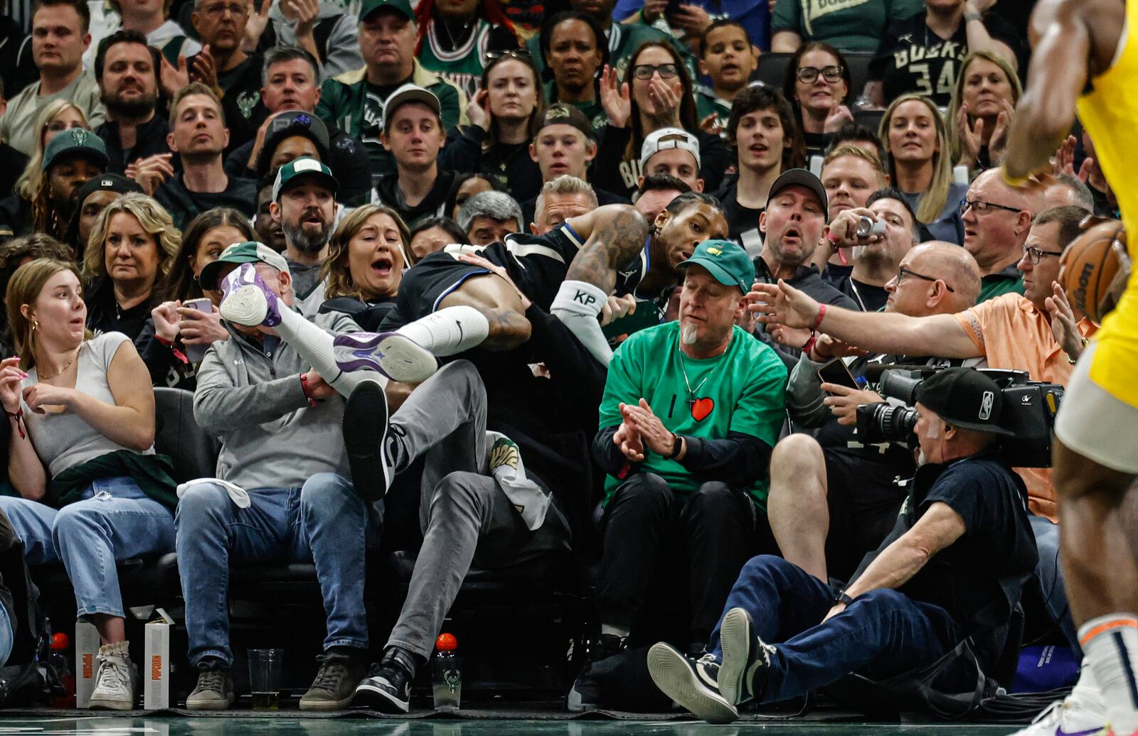 Milwaukee Bucks' Kevin Porter Jr. leaps into the crowd trying to save a ball against the Indiana Pacers during the first half of Game 4 of a first-round NBA basketball playoff series Sunday, April 27, 2025, in Milwaukee. (AP Photo/Jeffrey Phelps)