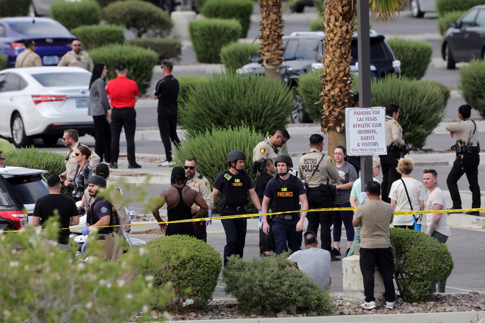 Las Vegas Metro Police officers talk with gym members after a shooting at a Las Vegas Athletic Club Friday, May 16, 2025, in Las Vegas. (Steve Marcus/Las Vegas Sun via AP)