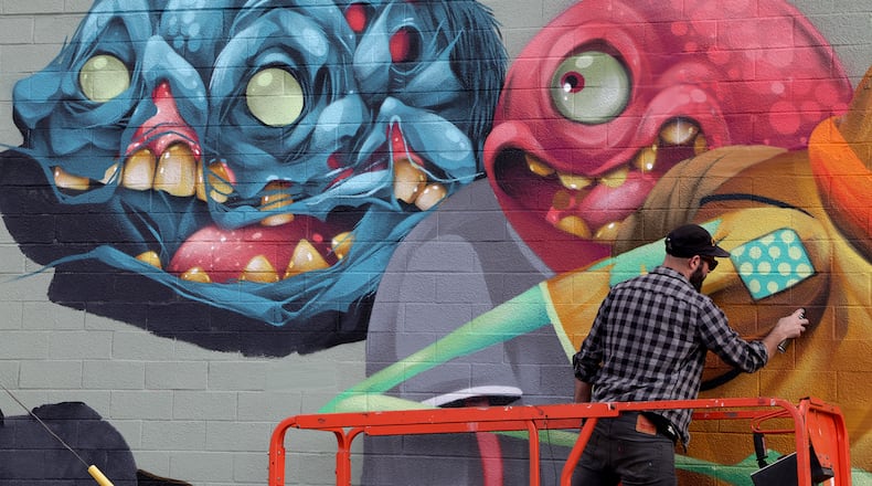 Steve Ehret, an artist from Canton, Ohio, shares his imagination and creativity with Springfield as he created a mural on the side of a building along Columbia Street in downtown last year. BILL LACKEY/STAFF