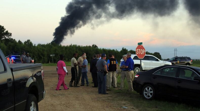 Emergency officials respond to the site of a military plane crash near Itta Bena, Miss., Monday, July 10, 2017. Leflore County Emergency Management Agency Director Frank Randle told reporters at a late briefing that more than a dozen bodies had been recovered after the KC-130 spiraled into the ground about 85 miles (135 kilometers) north of Jackson in the Mississippi Delta. (Elijah Baylis/The Clarion-Ledger via AP)