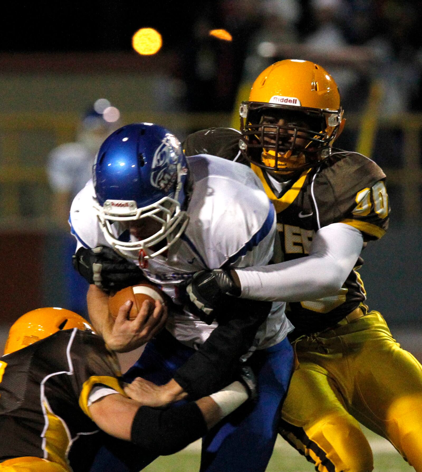 The Alter Knights Dean Lemon takes down Clinton-Massie's Bayle Wolfe Friday night at Welcome Stadium in the Division IV, Region 14 final. LISA POWELL / STAFF