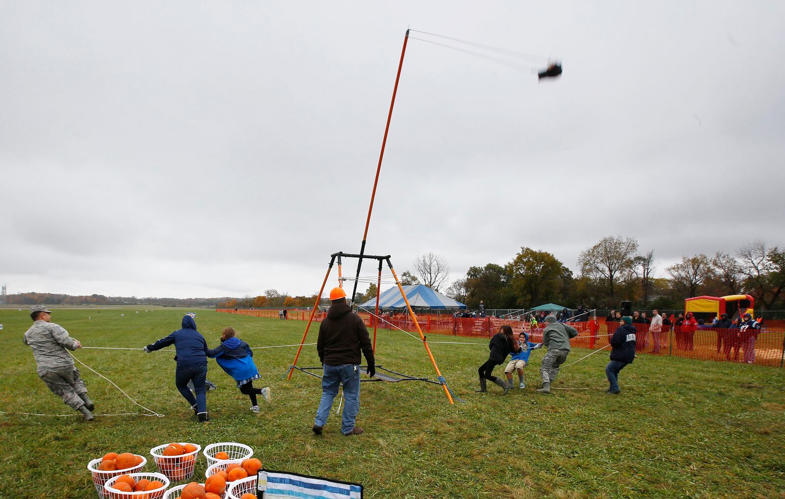 A human-powered pumpkin launcher swings into action as ropes are pulled on each side of the machine at Wright-Patterson Air Force Base on Friday afternoon.  The 14th annual Pumpkin Chuck was sponsored by the Air Force Life Cycle Management Center Engineering Directorate's STEM outreach.  More than 40 participants worked a dozen chucking machines to launch pumpkins from two pounds to 10 pounds as far as 3,800 feet.   TY GREENLEES / STAFF