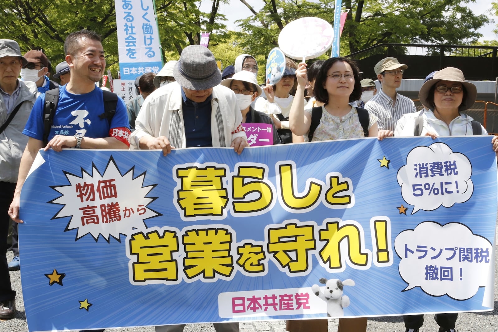 Peoeple march through the streets to mark May Day in Tokyo Thursday, May 1, 2025. A banner reads "Protect life and business." (AP Photo/Yuri Kageyama)