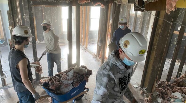 Habitat for Humanity and Cliff Park School worked together on a Springfield house, which is now complete for keys to be handed over to the new owner on Jan. 13. Work on the South Bell Street house started in 2021. Cliff Park students are shown doing demolition work early in the project. CONTRIBUTED