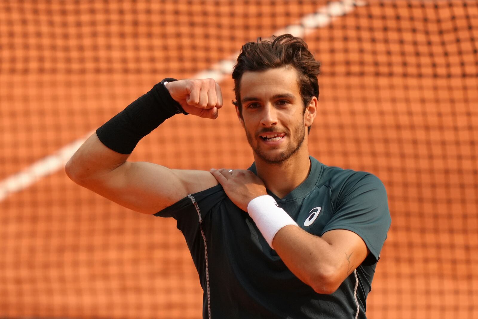 Italy's Lorenzo Musetti celebrates as he won the quarterfinal match of the French Tennis Open against Frances Tiafoe of the U.S. at the Roland-Garros stadium in Paris, Tuesday, June 3, 2025. (AP Photo/Aurelien Morissard)