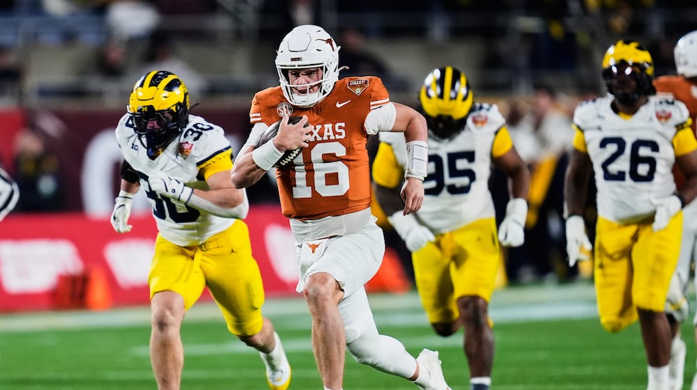 Texas quarterback Arch Manning (16) outruns the Michigan defense on his way to a 60-yard touchdown run during the second half of the Citrus Bowl NCAA college football game, Wednesday, Dec. 31, 2025, in Orlando, Fla. (AP Photo/John Raoux)