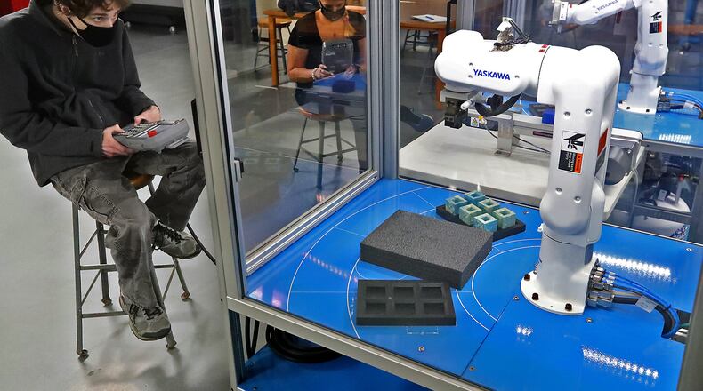 Clark State students, Liam Sprinkle and Amanda Drugman work in the school's robotics lab Thursday. BILL LACKEY/STAFF