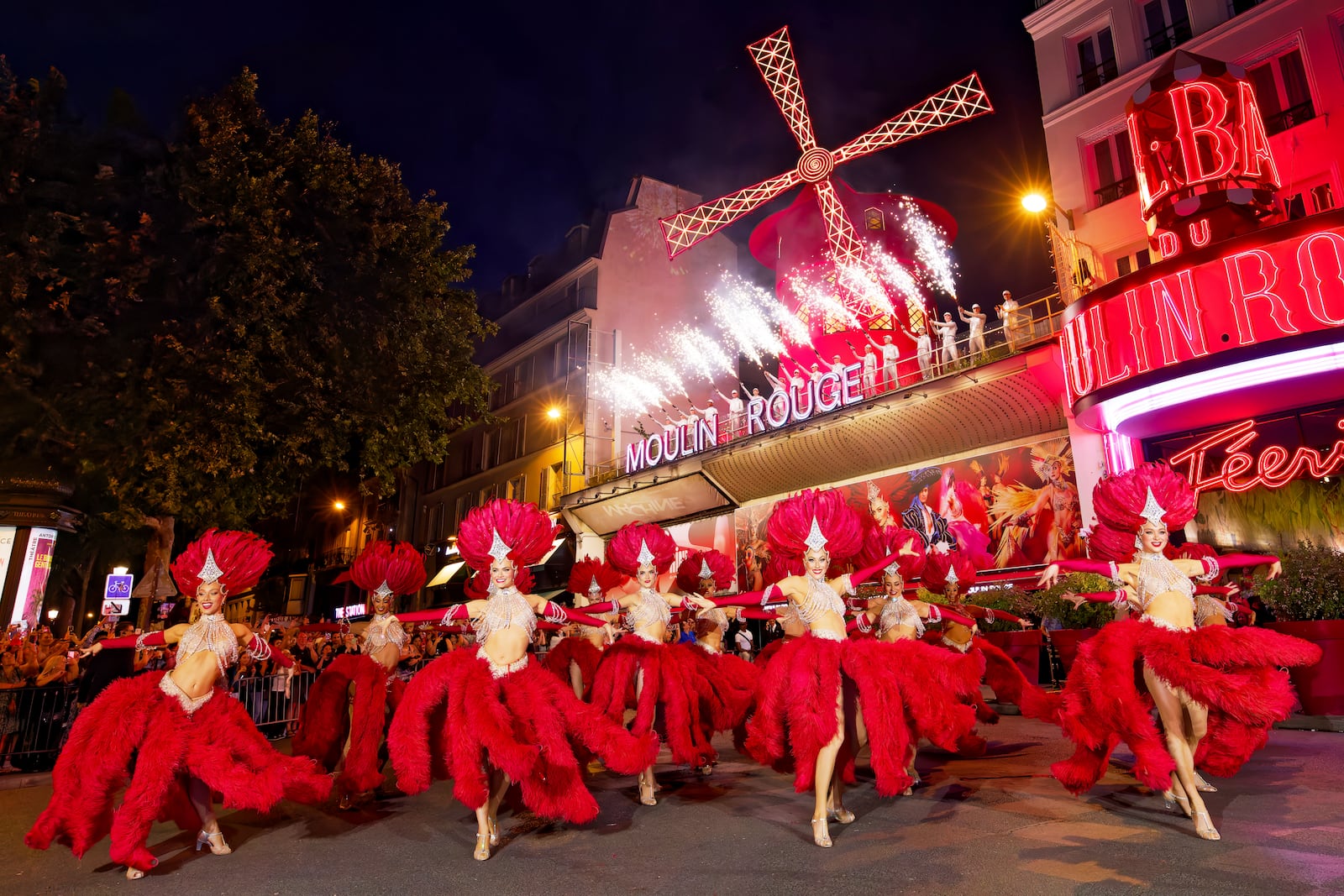 Dancers perform outside the Moulin Rouge cabaret to mark the mill's huge sails return to operation, Thursday July 10, 2025. (Moulin Rouge via AP)