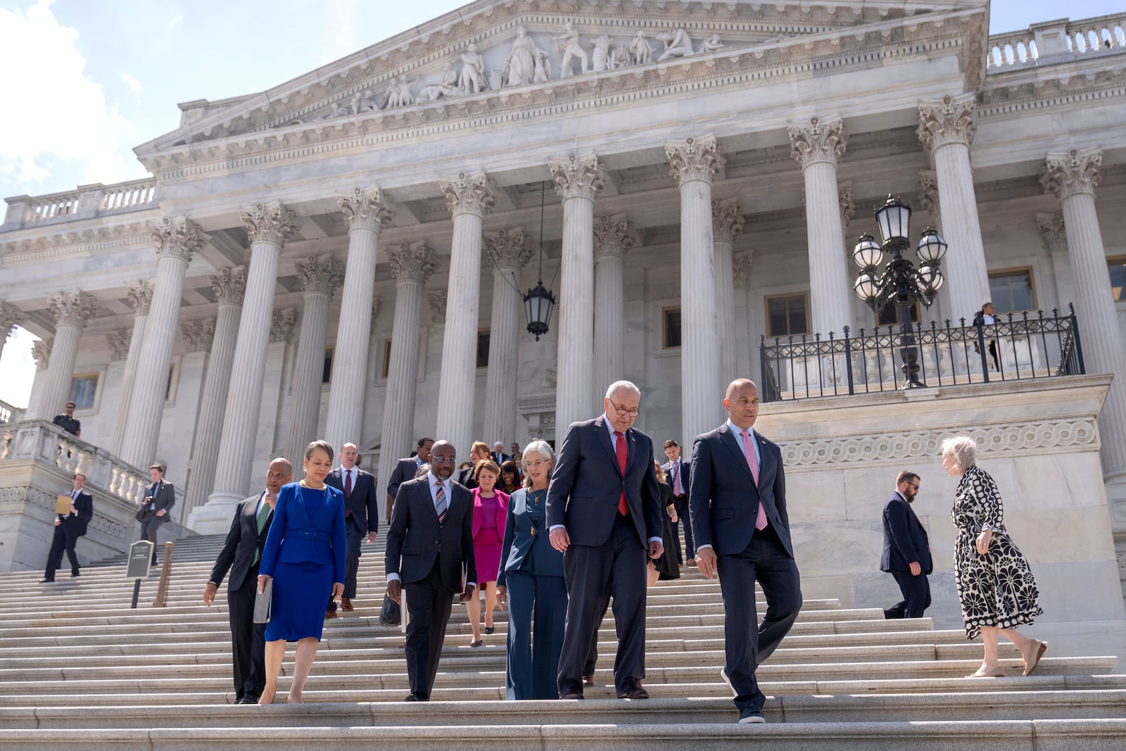 Senate Minority Leader Chuck Schumer, of N.Y., second from right, and House Minority Leader Hakeem Jeffries, of N.Y., right, arrive with other House and Senate Democrats for an event to mark 100 days of President Donald Trump's term on the steps of the Senate on Capitol Hill, Wednesday, April 30, 2025, in Washington. (AP Photo/Mark Schiefelbein)