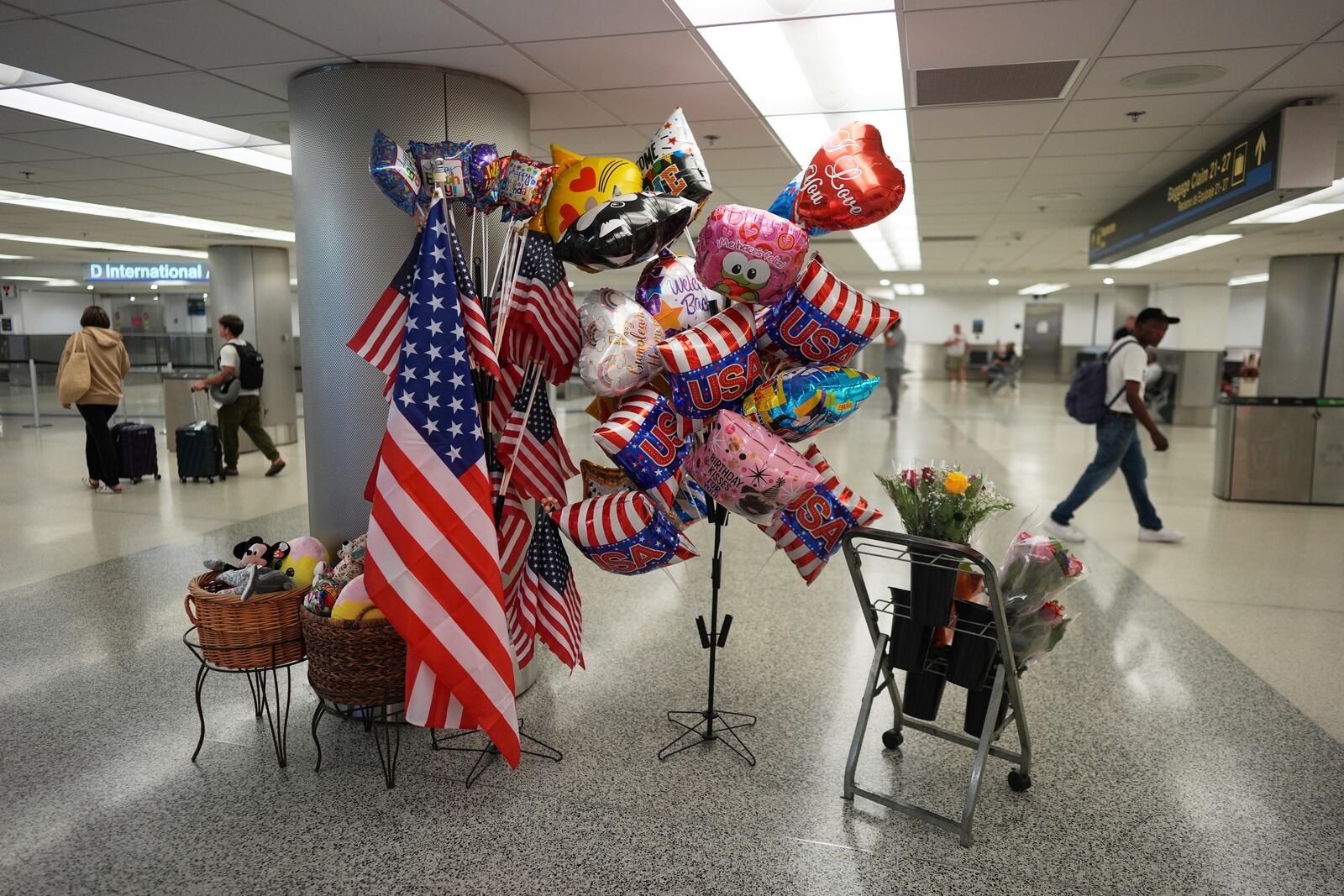USA balloons and American flags are displayed for sale near international arrivals at Miami International Airport, Monday, June 9, 2025, in Miami. (AP Photo/Rebecca Blackwell)
