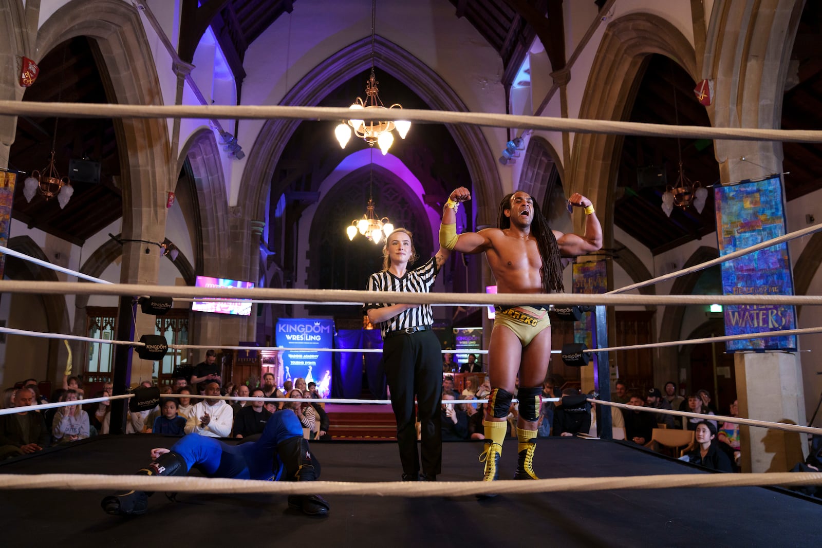 Wesley Nsereko, right, is proclaimed victor over Daemon Crowe aka Liam Ledger by referee Kate Crosby during a Kingdom Wrestling show at St Peter's Church in Shipley, Saturday, March 29, 2025. (AP Photo/Jon Super)