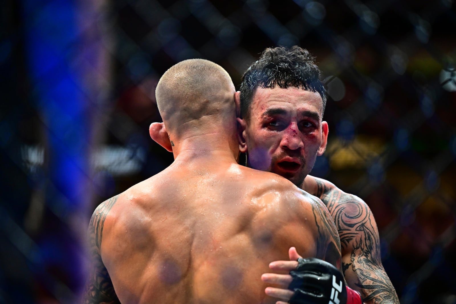 Dustin Poirier, left, celebrates with Max Holloway after the lightweight title fight at UFC 318 in New Orleans, La., Saturday, July 19, 2025. (AP Photo/Ella Hall)