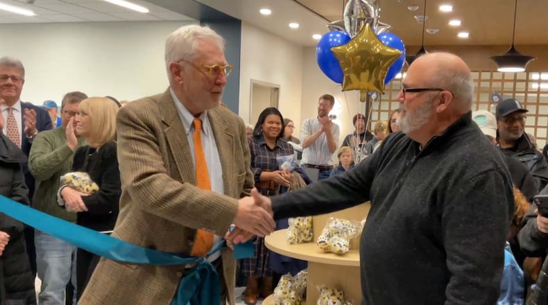 Rick Hoppes, son of Mary Chapman Hoppes, (left) and Clark County Public Library Director Bill Martino (right) shake hands after cutting the ribbon at the main entry of the Northridge branch while celebrating the opening of Northridge’s Mary C. Hoppes Children’s Library. CONTRIBUTED