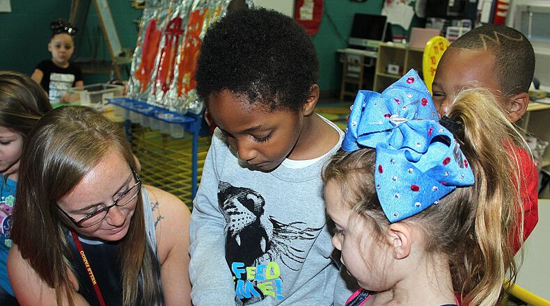 Springfield City Schools Early Learning Center teacher (left) Cortney Moore shows students a recently hatched chick. JEFF GUERINI/STAFF