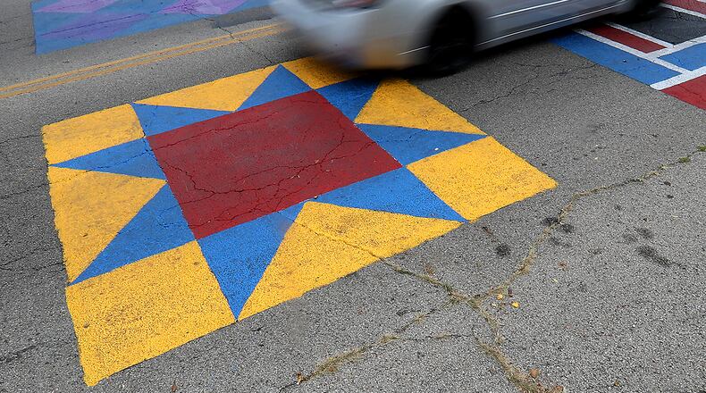 Members of the City of Springfield Community Development Department partnered Engaged Neighborhood Residents to paint street murals at the intersection of South Center Street and West Clark Street. The street murals took inspiration from traditional Signal Quilt Blocks that were used to communicate information along the Underground Railroad. BILL LACKEY/STAFF