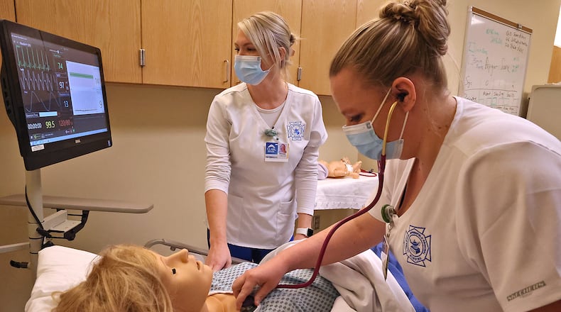 Kristin Cosby, left, and Kristin Sebastian, nursing students at Clark State, in one of the school's nursing labs. BILL LACKEY/STAFF