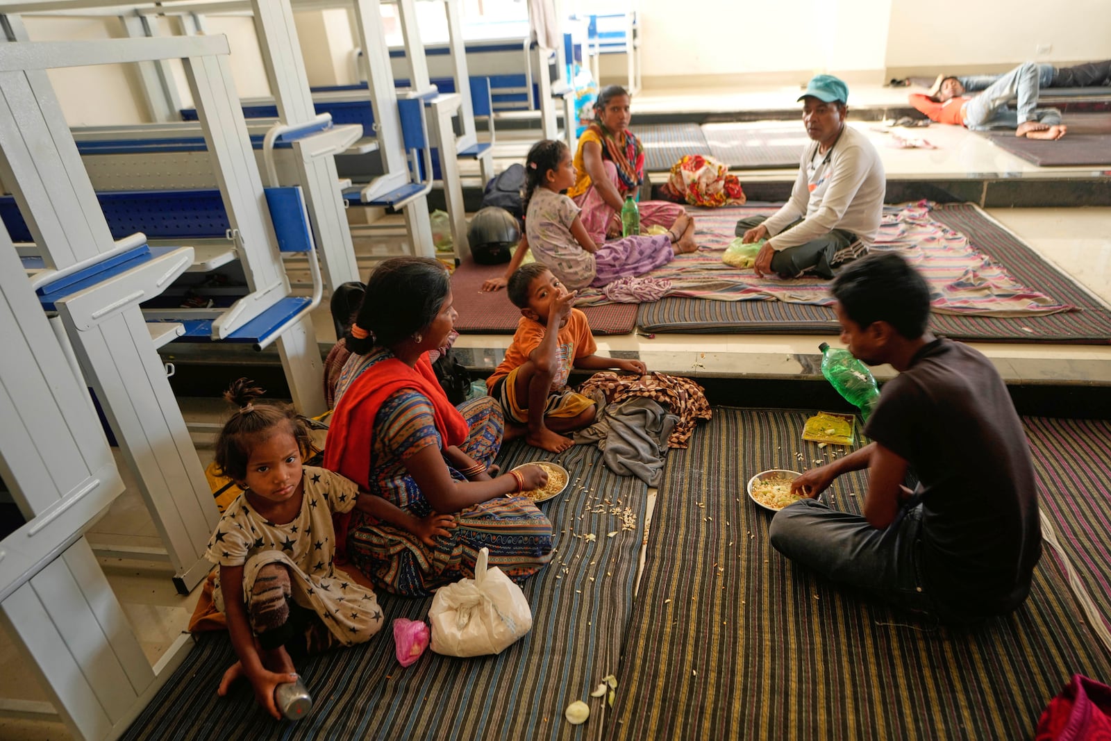 Villagers living along the border between India and Pakistan have food at a college where they have taken shelter following artillery shelling from Pakistan, on the outskirts of Jammu, India, Friday, May 9, 2025.(AP Photo/Channi Anand)