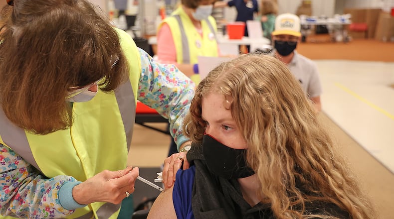 Cayla Moore, 16, received her first COVID vaccine injection in March at the Clark County vaccine distribution center at the Upper Vally Mall. Clark and Champaign County health districts are starting to set up clinics in schools to make the vaccine more readily available to students, school staff and communities. BILL LACKEY/STAFF