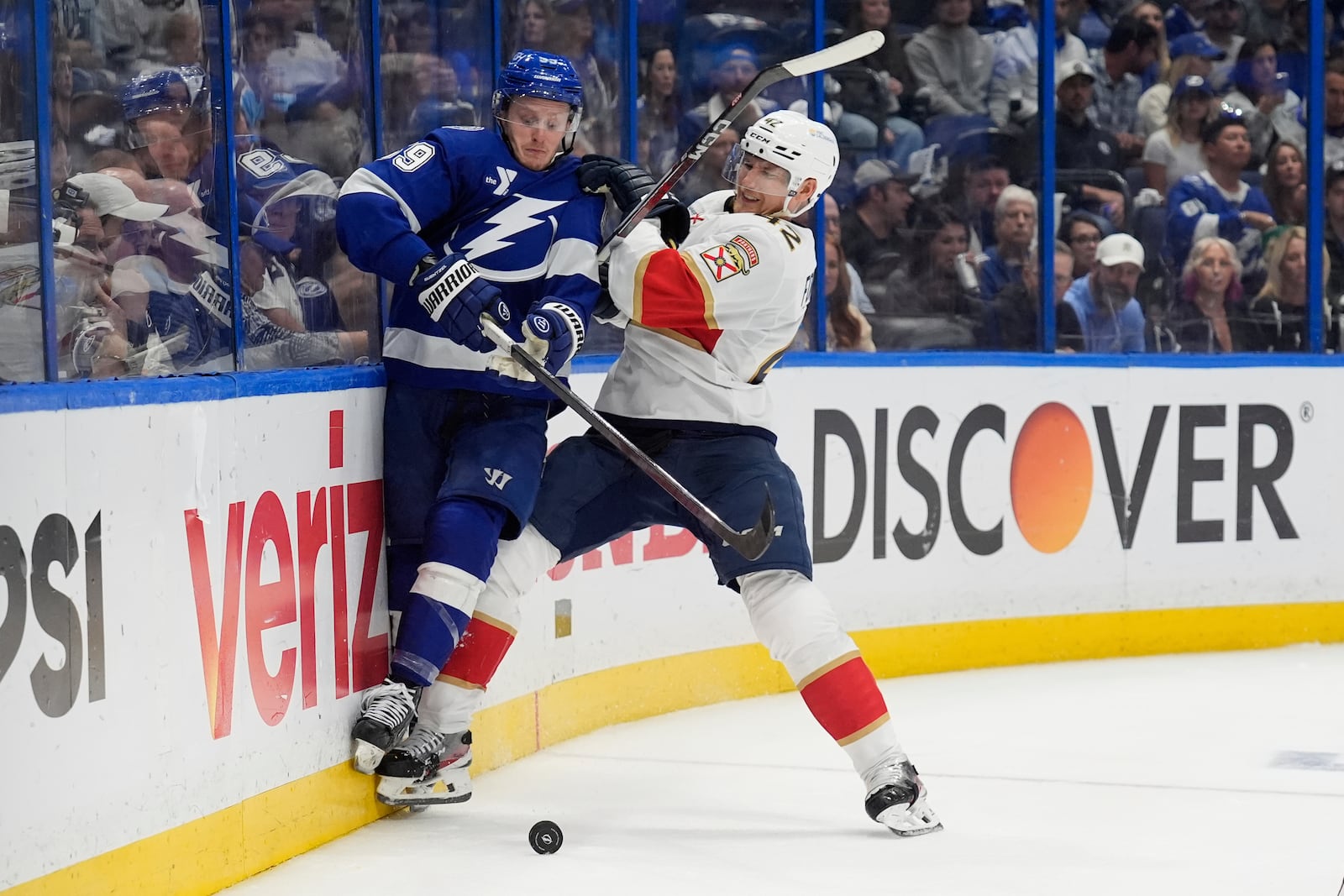 Florida Panthers defenseman Gustav Forsling (42) checks Tampa Bay Lightning center Jake Guentzel (59) into the dasher during the second period in Game 5 of an NHL hockey Stanley Cup first-round playoff series, Wednesday, April 30, 2025, in Tampa, Fla. (AP Photo/Chris O'Meara)