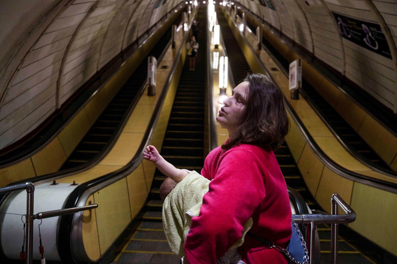 A woman calms her son as she takes cover at a metro station during a Russian drone strike on Kyiv, Ukraine, Tuesday, June 10, 2025. (AP Photo/Evgeniy Maloletka)