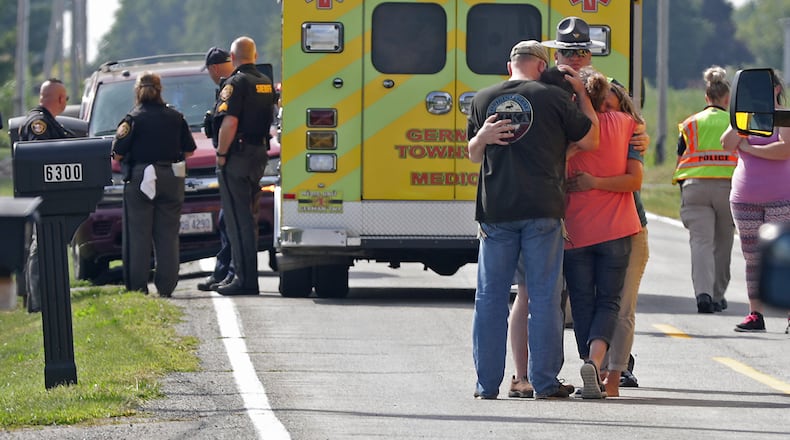 Family members hug each other in the middle of Ballentine Pike in German Township after a 7-year-old boy going to get the mail was struck and killed by an SUV. BILL LACKEY/STAFF
