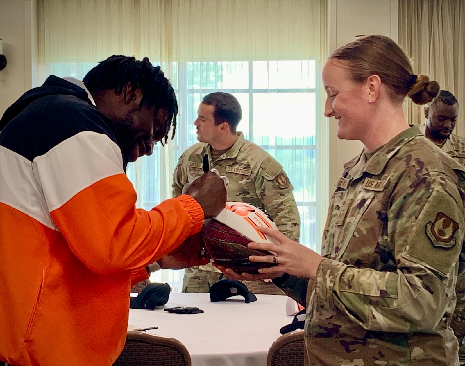 Cincinnati Bengals rookie Demetrius Knight Jr. signs a football for Staff Sgt. Tanya Stewart during a Bengals visit to Wright-Patterson Air Force Base, Friday, June 6, 2025. LONDON BISHOP/STAFF