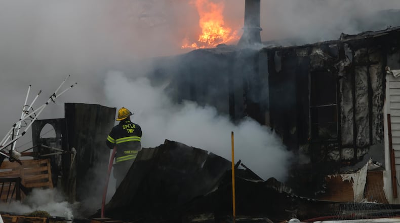 Firefighters fight a house fire on the 10000 block of Plattsburg Road in Harmony Twp. Thursday, Feb. 22, 2024. BILL LACKEY/STAFF
