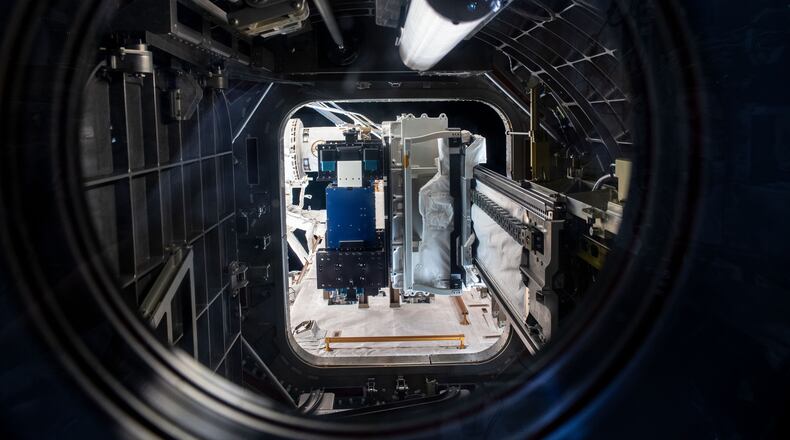 Materials International Space Station Experiment, or MISSE, shown in the blue panel on the airlock slide tray at the International Space Station as the Special Purpose Dexterous Manipulator grapples it. The MISSE spaceflight experiment is a collaboration among the Air Force Research Laboratory, NASA, Georgia Tech Research Institute and DuPont to study the effects of space weather on spacecraft materials. (Photo credit/NASA)