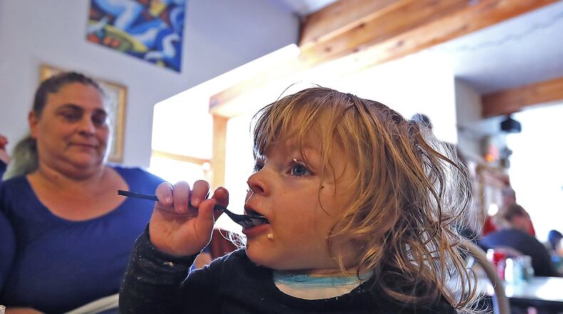 One year old Sophia Whitt was truly getting into her Italian Thanksgiving dinner, courtesy of Olive Garden, at the Springfield Soup Kitchen Thursday. Bill Lackey/Staff