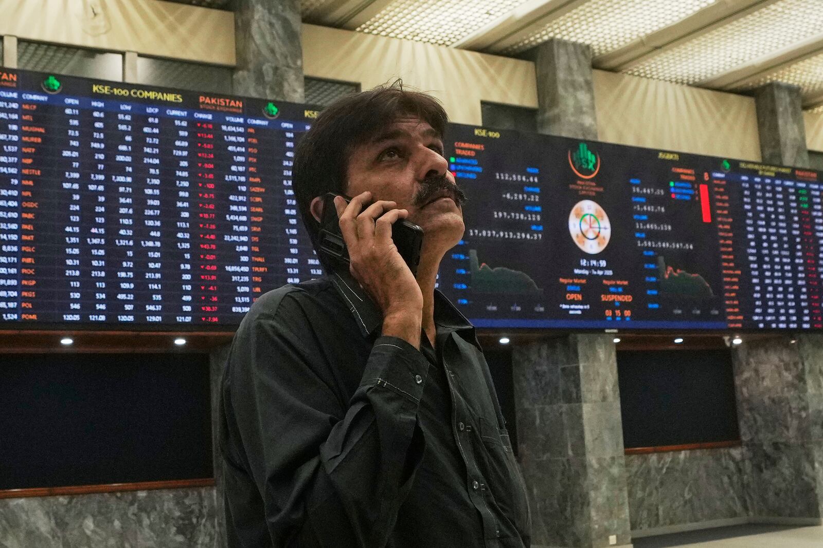 An investor looks on indexes and benchmark 100 index at the Pakistan Stock Exchange (PSE), in Karachi, Pakistan, Monday, April 7, 2025. (AP Photo/Fareed Khan)