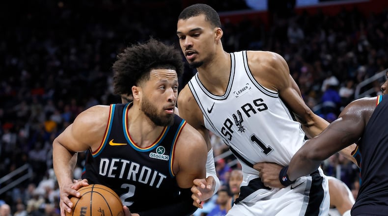 Detroit Pistons guard Cade Cunningham (2) drives against San Antonio Spurs forward Victor Wembanyama (1) during the second half of an NBA basketball game Monday, Feb. 23, 2026, in Detroit. (AP Photo/Duane Burleson)