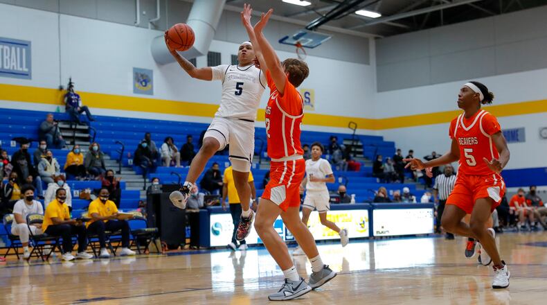 CUTLINE: Springfield High School senior Josh Tolliver shoots the ball over Beavercreek junior Gabe Phillips during their game on Friday night in Springfield. Tolliver scored a career-high 37 points as the Wildcats won 74-71. CONTRIBUTED PHOTO BY MICHAEL COOPER