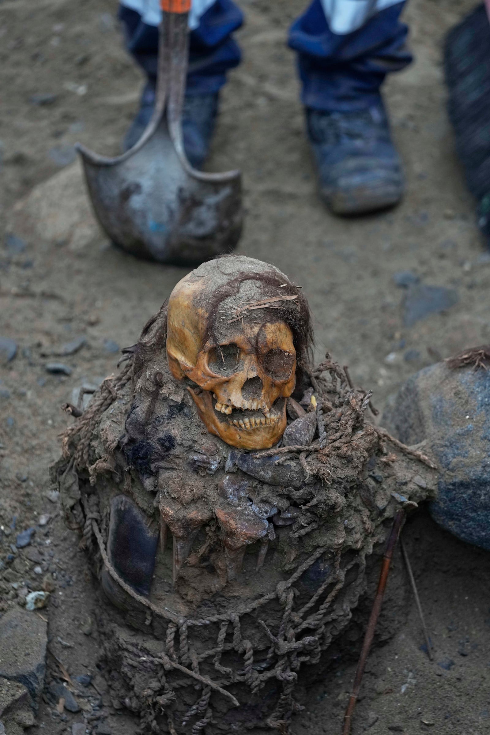 An ancient mummy which archeologists identify as female and from the pre-Inca Chancay culture is partially excavated after being discovered by city workers digging a natural gas line for the company Calidda in the district of Puente Piedra on the outskirts of Lima, Peru, Wednesday, June 18, 2025. (AP Photo/Martin Mejia)