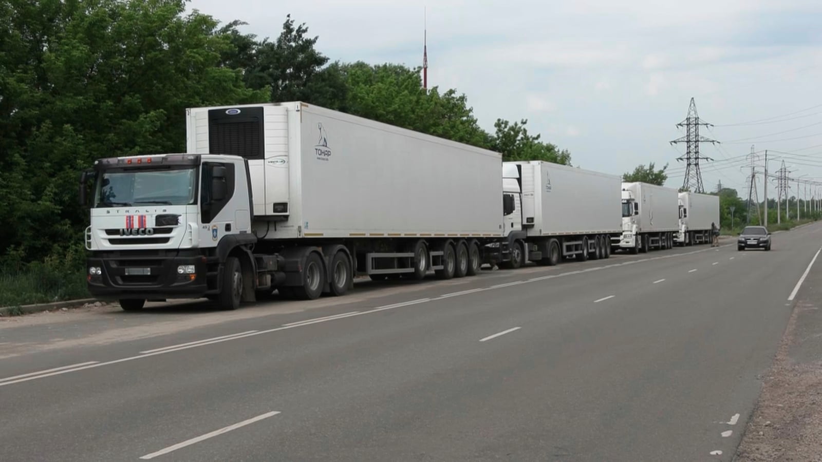 In this photo, taken from video distributed by Russian Defense Ministry Press Service on Sunday, June 8, 2025, the motorcade of refrigerators of the first convoy carrying bodies of Ukrainian soldiers for repatriation is parked at an exchange area near Novaya Guta, Belarus, for the beginning of a large-scale exchange between Russia and Ukraine. (Russian Defense Ministry Press Service via AP)