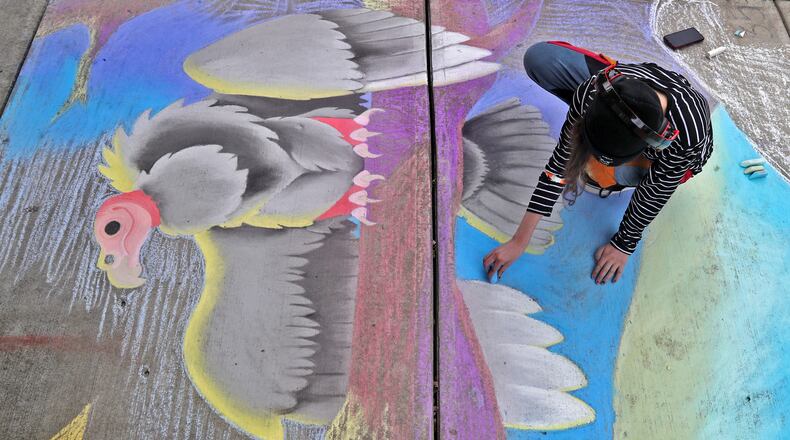 Jennah Kuhn works on her chalk artwork during the National Trail Parks and Recreation District's annual ChalkFest Saturday, Oct. 1, 2022 at National Road Commons Park. BILL LACKEY/STAFF