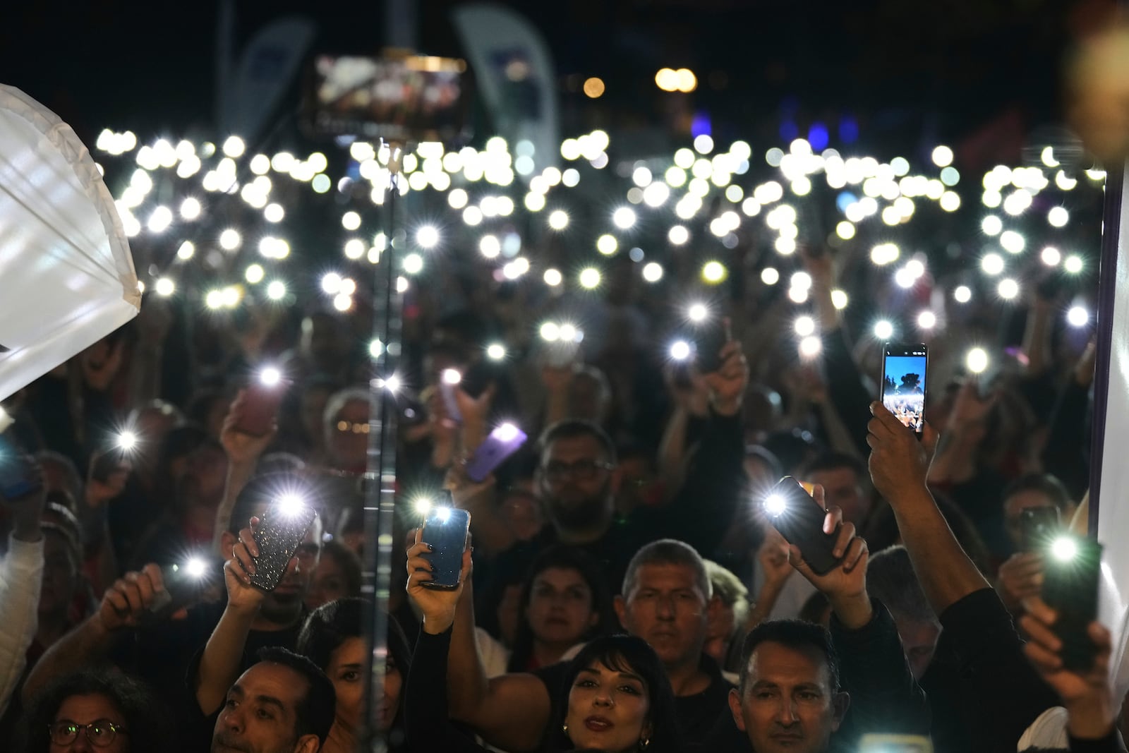 Turkish Cypriot protesters hold the lighted mobile phones aloft as as they gather to protest against what they say is Turkey's attempt to erode their secular roots and to strengthen the hold of political Islam over their society, in the northern half of ethnically divided Cyprus' capital Nicosia, on Friday, May 2, 2025. (AP Photo/Petros Karadjias)