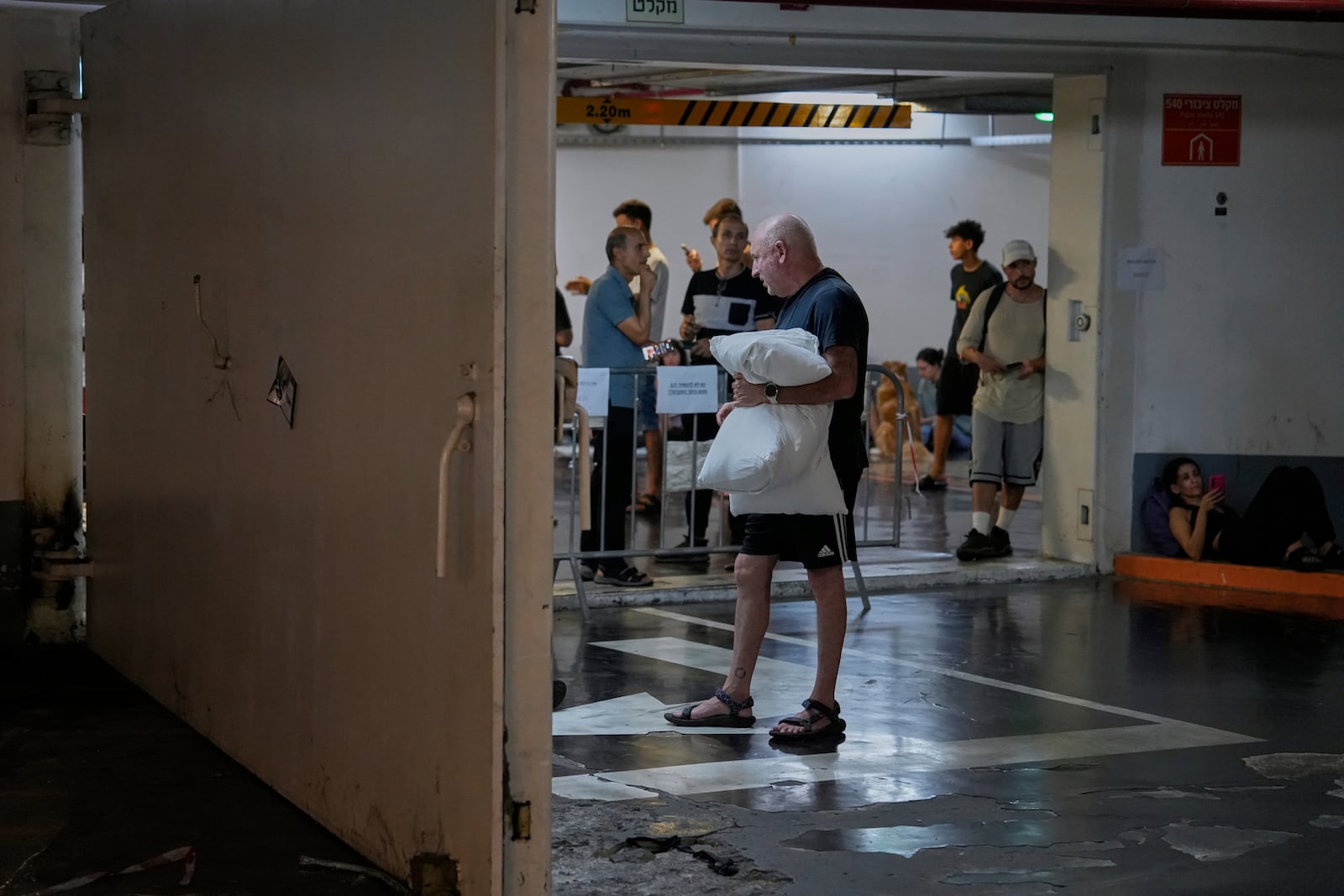 Israelis take shelter in a parking garage during a missile alert from Iran, in Tel Aviv, Israel, early Tuesday, June 17, 2025. (AP Photo/Baz Ratner)