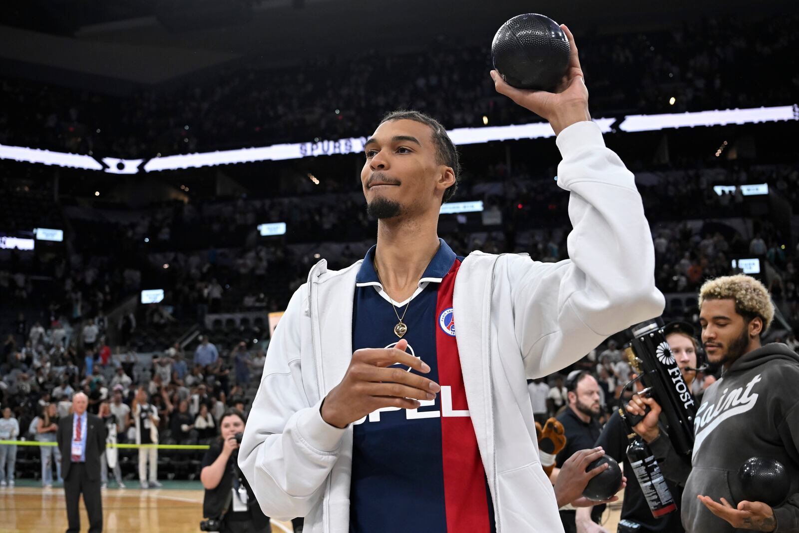 San Antonio Spurs forward Victor Wembanyama throws novelty basketballs to fans after an NBA basketball game against the Toronto Raptors, Sunday, April 13, 2025, in San Antonio. (AP Photo/Darren Abate)