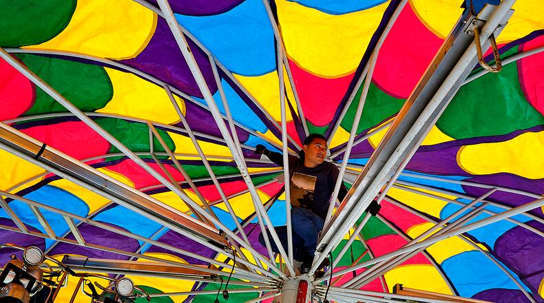 An employee of Chicketti Family Amusements sets up one of the amusement rides in front of Northeastern School on Thursday, Sept. 7, 2023, as he and his co-workers get ready for the South Vienna Corn Festival that starts Friday afternoon. BILL LACKEY/STAFF