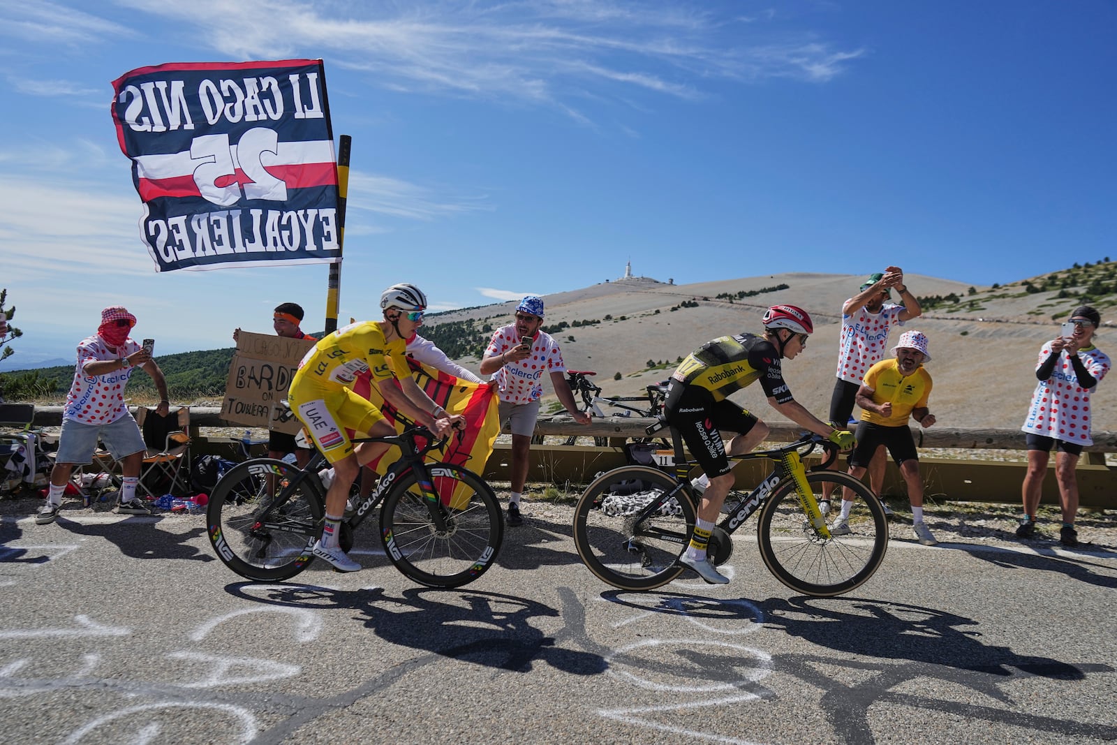 Slovenia's Tadej Pogacar, wearing the overall leader's yellow jersey, follows Denmark's Jonas Vingegaard as they climb to the summit of Mont Ventoux, rear, during the sixteenth stage of the Tour de France cycling race over 171.5 kilometers (106.6 miles) with start in Montpellier and finish on the Mont Ventoux, France, Tuesday, July 22, 2025. (AP Photo/Thibault Camus)