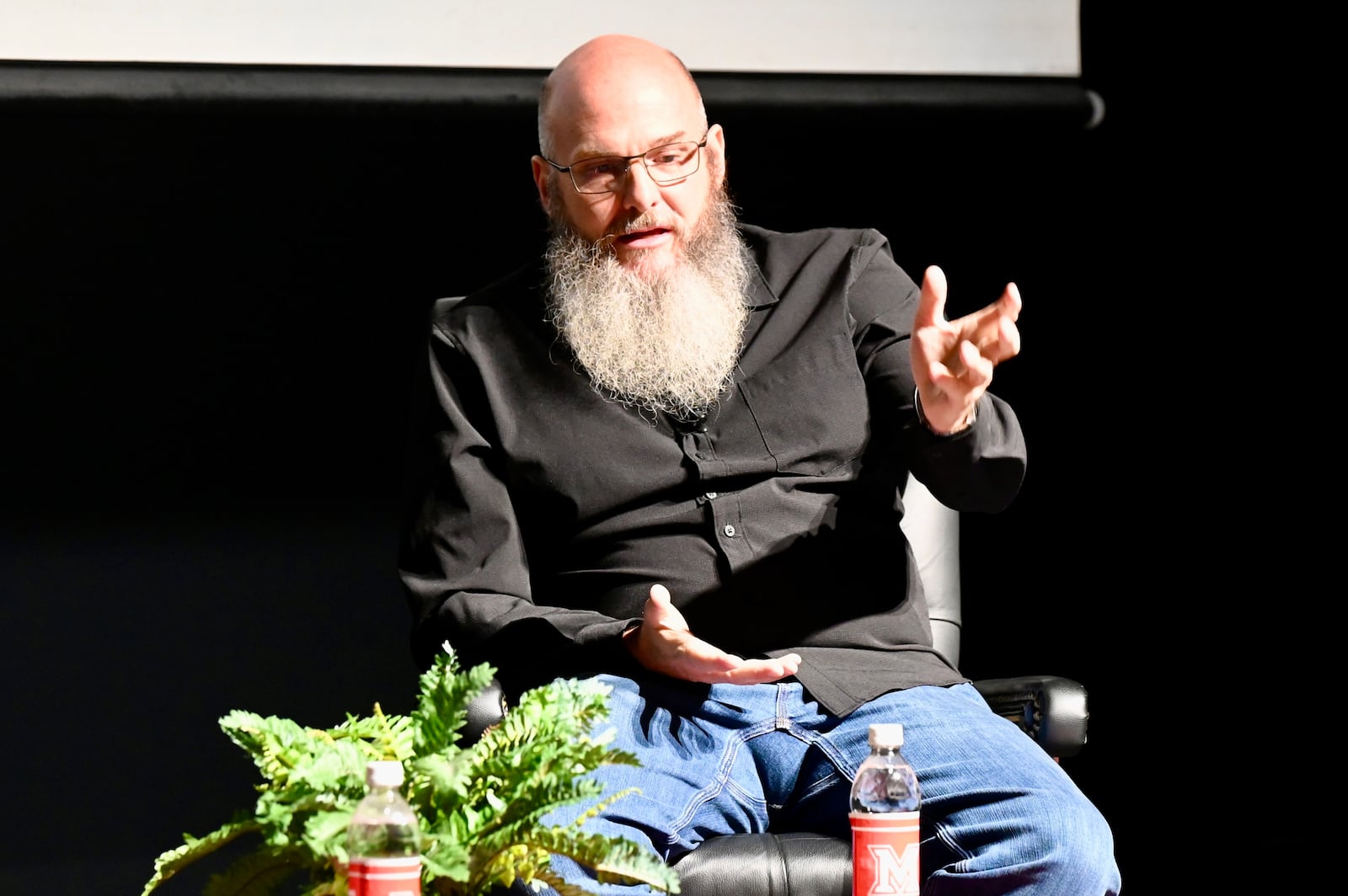 Pinball Garage owner Brad Baker asks entrepreneur Daymond John, who is one of the investors on the television show Shark Tank, Thursday evening, Nov. 14, 2025, on the Parrish Auditorium stage at Miami University Hamilton. The interview and discussion was part of the Harry T. Wilks Distinguished Lecture Series. John, known as "The People's Shark," invested in Baker's VPcabs Virtual Pinball business in 2016, which he has since sold. MICHAEL D. PITMAN/STAFF