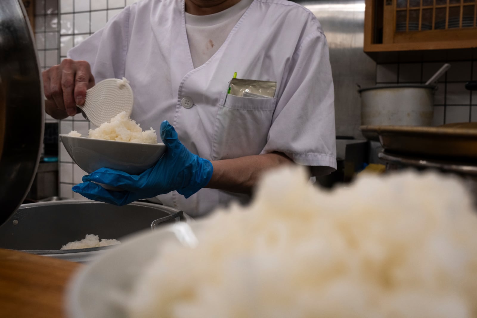 An employee prepares a bowl of rice at a restaurant in Tokyo, Thursday, May 22, 2025. (AP Photo/Louise Delmotte)