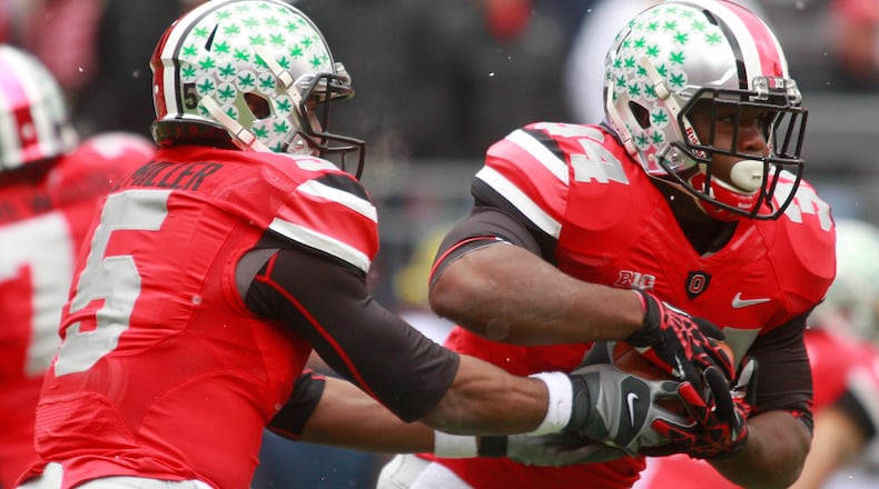 Ohio State quarterback Braxton Miller (5) hands off to Carlos Hyde (34) during Saturday's game against Michigan.The Ohio State University Buckeyes beat Michigan 26-21 to finish an undefeated 12-0 season at home in Ohio Stadium on Saturday, Nov. 24, 2012.Photo by Barbara J. Perenic/Cox Media Group