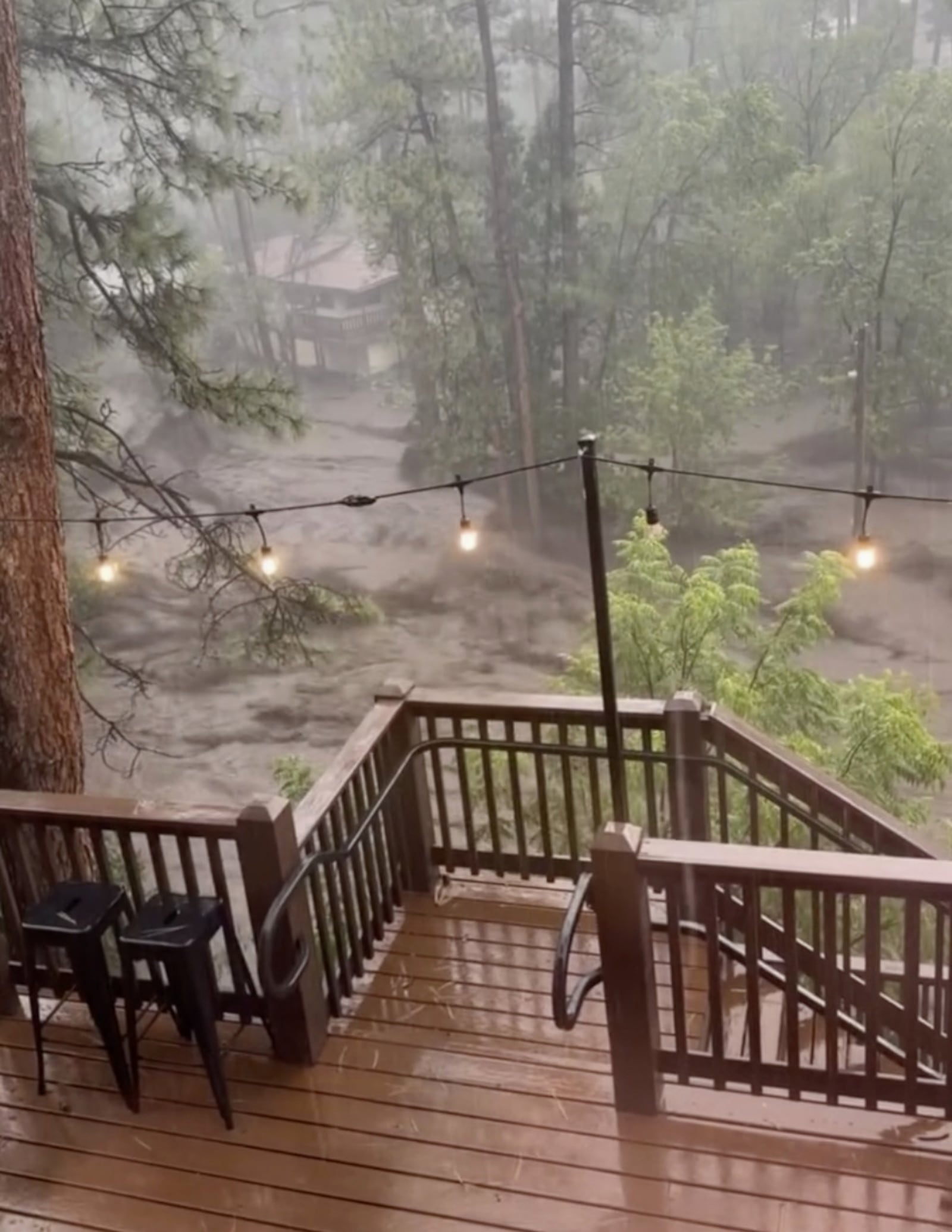 In this image taken from video, flash flooding is seen behind a house in Ruidoso, N.M., Tuesday, July 8, 2025. (Kaitlyn Carpenter via AP)