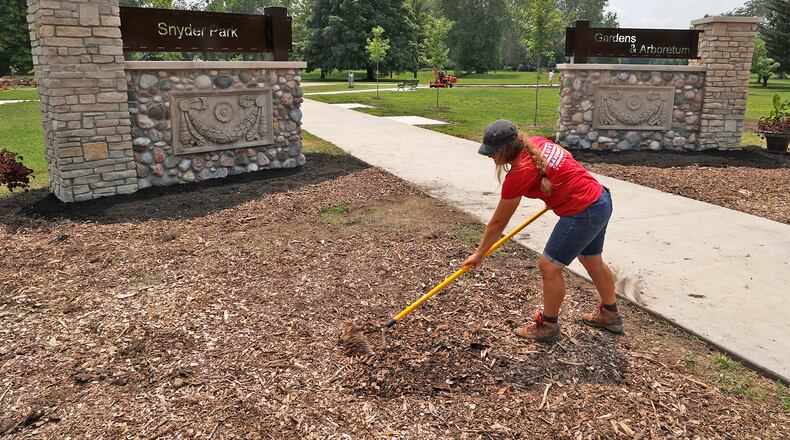 Beth Brooks, Horticulture Program Assistant for OSU Extension, rakes the mulch in front of the new gateway into Snyder Park Gardens & Arboretum Tuesday, August 1, 2023. The staff and volunteers have been busy getting ready for the Jubilee celebration of Saturday. BILL LACKEY/STAFF
