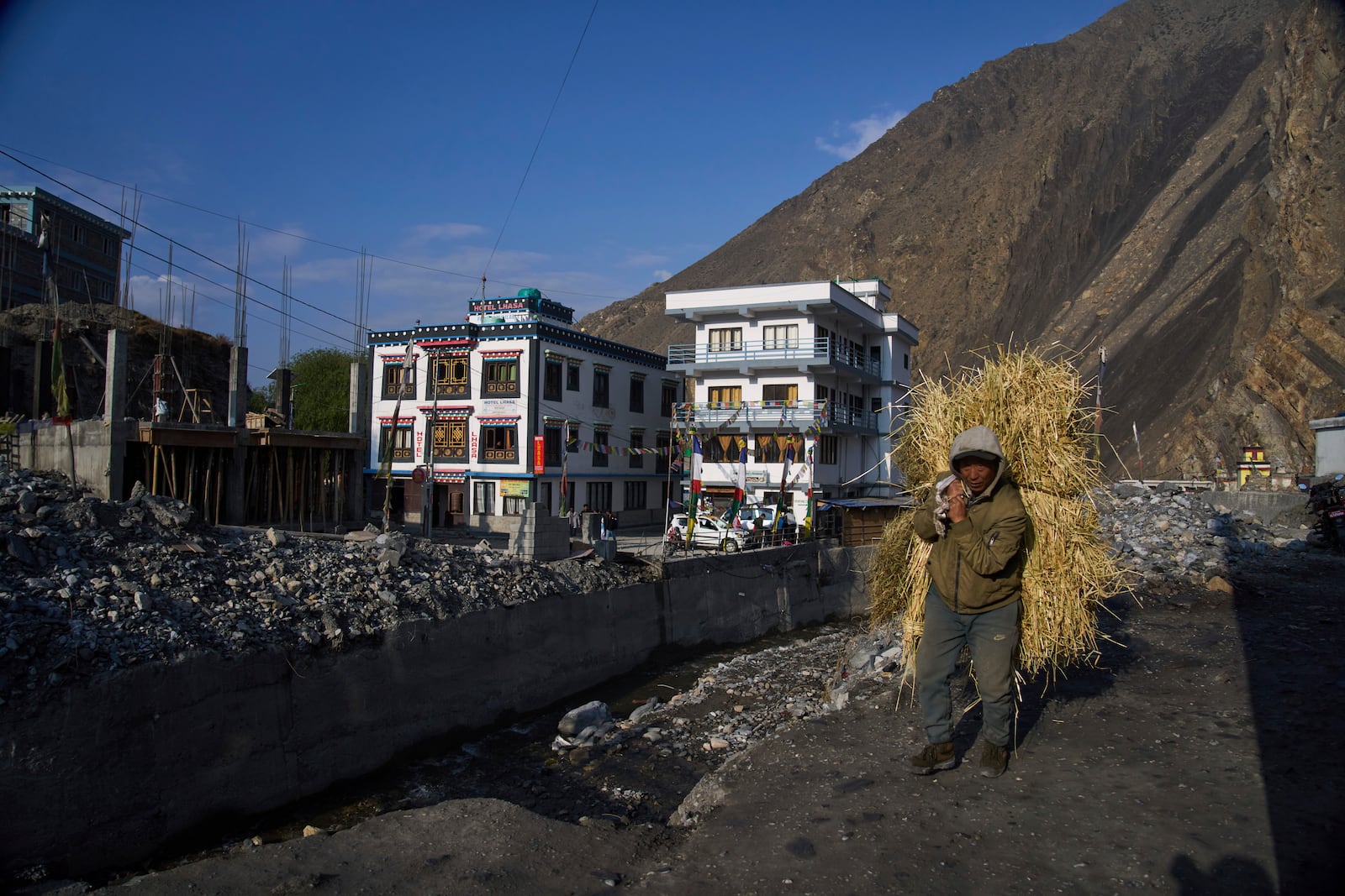 A man carries hay for his livestock in Kagbeni, Mustang region,462 kilometers (288 miles) west of Kathmandu, Nepal,Thursday, April 17, 2025. (AP Photo/Niranjan Shrestha)