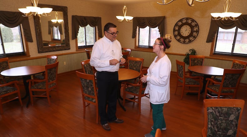Bill Robinson, executive director of Villa Springfield, talks with nurse Sarah Ruf, who has worked at Villa since she was 15 in a dinning room. BILL LACKEY/STAFF